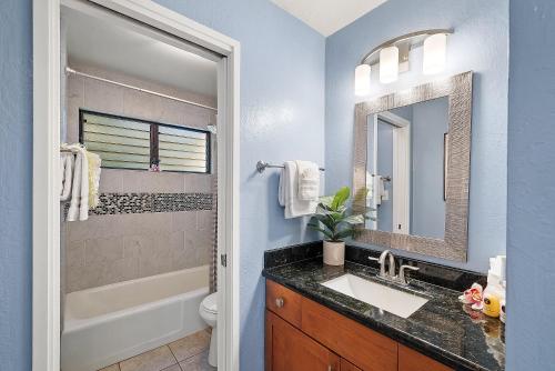 a bathroom with a sink and a toilet and a mirror at Kihei Resort 127 · KRS 127 Relaxing 1BD Condo w AC Pool Beach Ne in Kihei