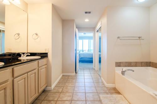 une salle de bains avec baignoire et lavabo dans l'établissement Beachview Condo in Legacy Tower 1 -1104 - fully furnished 2 bedroom 2 bath, à De Buys