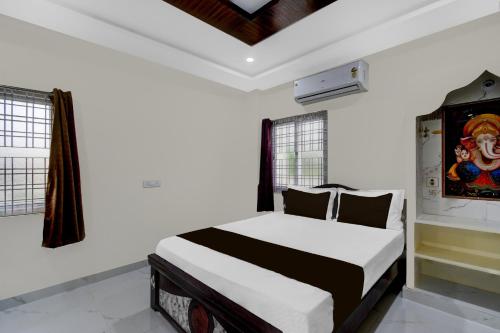 a bedroom with a bed with white walls and windows at Hotel O Infocity Ghatkesar Formerly SR Grand in Bībīnagar