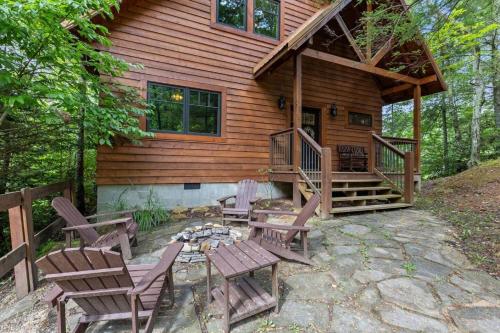 a log cabin with chairs and a fire pit in front of it at Hot Tub & WiFi - Sky Pointe - LUX cabin in RRG KY in Rogers