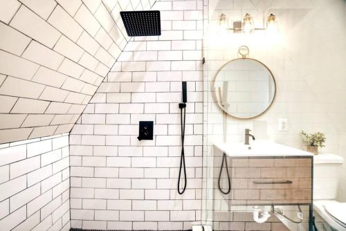 a white bathroom with a shower and a sink at The Black Aframe - HOT TUB and Mountain Views in Evergreen Farms