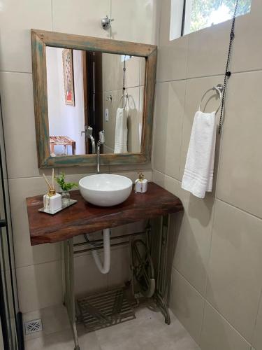 a bathroom with a sink and a mirror at Chalés Quintal da Serra in Lavrinhas