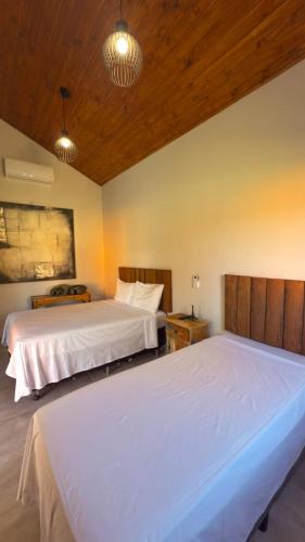 two beds in a room with two beds sidx sidx sidx at Chalés Quintal da Serra in Lavrinhas