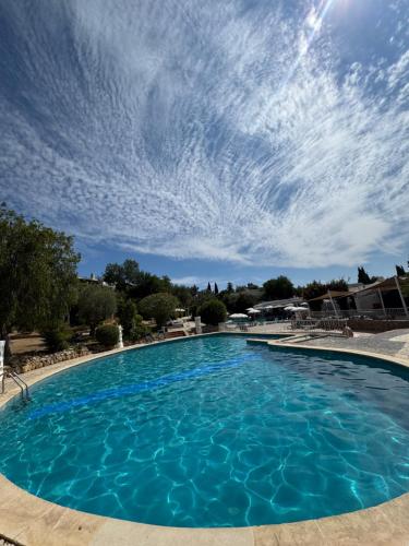 a large blue swimming pool with a cloudy sky at Villa Valentina-Sunny 2 Bedroom House with Pool in Carvoeiro