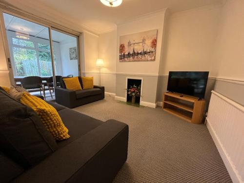 a living room with a couch and a flat screen tv at Pitfold Road in London