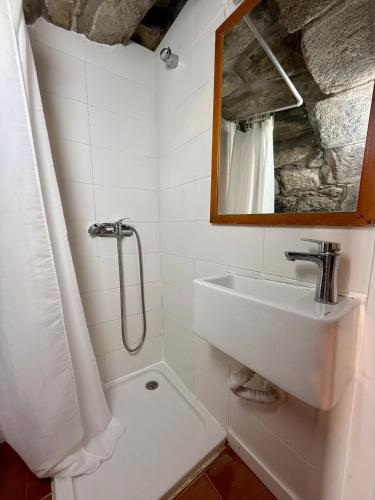 a white bathroom with a sink and a mirror at Haven Azores in Faial da Terra