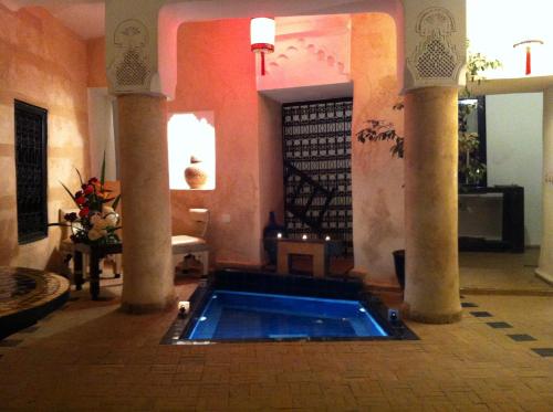 einen Pool in einem Zimmer mit zwei Säulen in der Unterkunft Riad Sabbah in Marrakesch