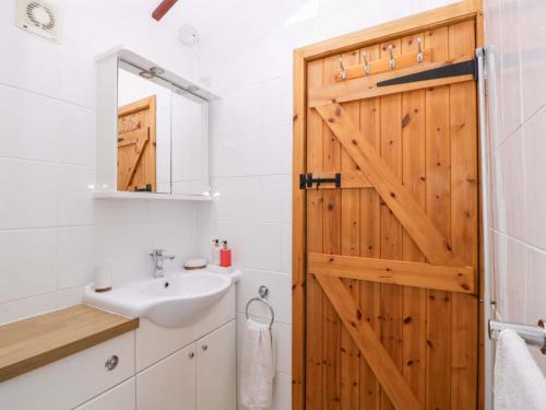 a bathroom with a wooden door and a sink at The Log Cabin in Gloucester