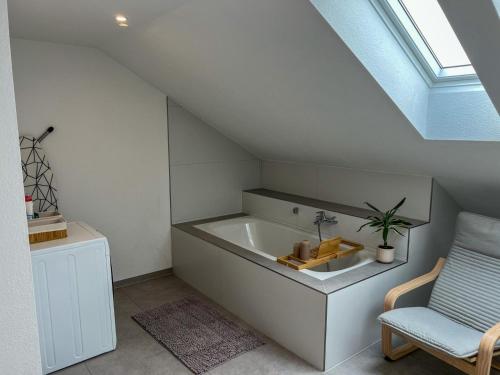 a attic bathroom with a sink and a chair at MaMa-Apartments - Netflix, Balkon, Kaffee & Tee, WIFI, Waschmaschine, familienfreundlich, kostenloser Parkplatz - 125 qm in Fulda
