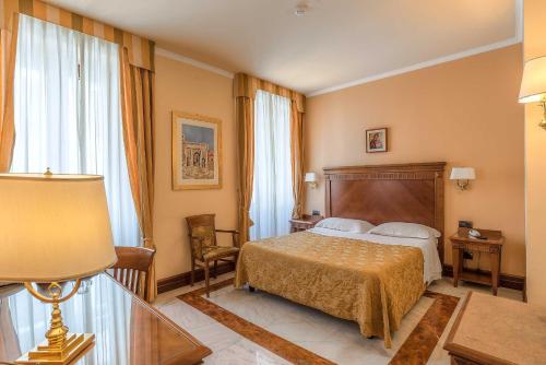 um quarto de hotel com uma cama e um candeeiro em Tmark Hotel Vaticano em Roma