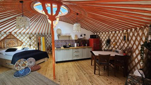 AdamowにあるKrólikowe Chatyのベッド1台とテーブル付きのテントの部屋