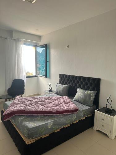 a bedroom with a bed and a chair and a window at Paradis résidence473 in Oran