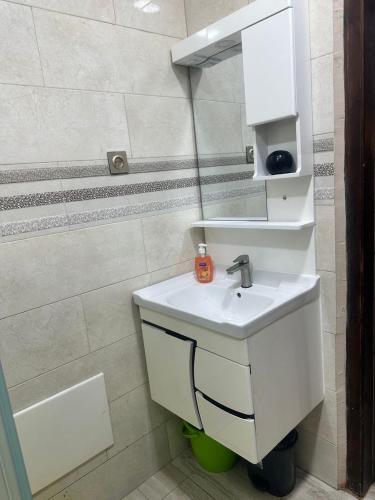 a white bathroom with a sink and a mirror at Paradis résidence473 in Oran