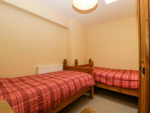 a bedroom with two beds and a ceiling at Dovecote Cottage in Gloucester