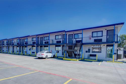 ein Gebäude mit einem auf einem Parkplatz geparkten Auto in der Unterkunft Super 7 Inn By OYO San Antonio NW Medical Center in San Antonio