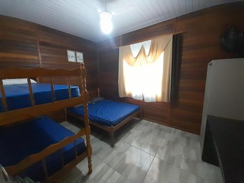 瓜拉图巴Casa Colonial em Guaratuba, próximo a praia的一间卧室，有两张双层床和一扇窗户