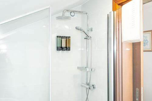 a shower with a glass door in a bathroom at Horizonte Azul in Ponta do Sol