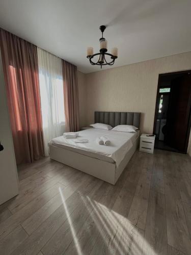 a bedroom with a large white bed and wooden floors at Lucky House in Grigoleti