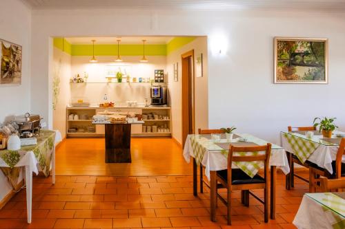 a restaurant with two tables and a kitchen in the background at Hotel Larverde in Sertã