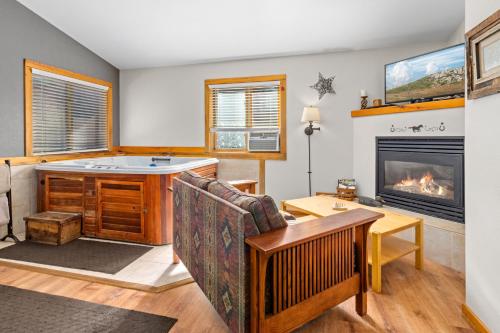 a living room with a tub and a fireplace at Mountain Shadows Resort in Estes Park