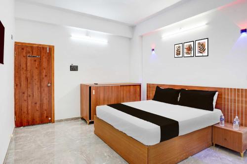 - une chambre avec un lit et une porte en bois dans l'établissement Hotel O DSP Lodge And Restaurant, à Jadhavwadi