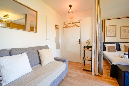 a room with a couch and a sink and a mirror at Le Cocon à 15 minutes de Disneyland Paris in Bussy-Saint-Georges