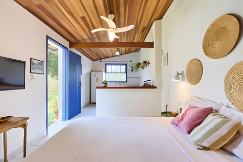 a bedroom with a large bed with a wooden ceiling at Chalé no Itaguá, ao lado do aquário de Ubatuba in Ubatuba
