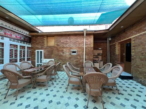 a patio with tables and chairs and a brick wall at Shahina in Samarkand