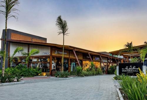 a building with a palm tree in front of it at Apartamento com vista pro mar no Centro de Ubatuba - com estacionamento 2 quartos e cozinha completa in Ubatuba