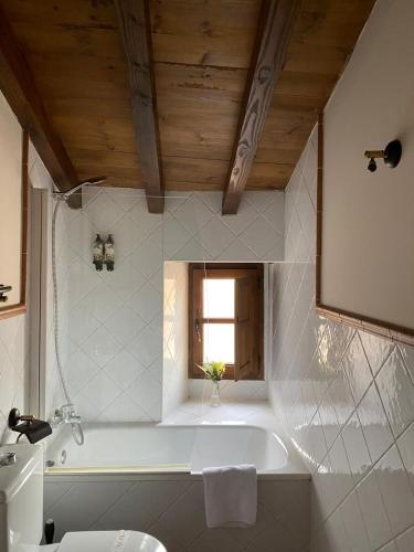 a white bathroom with a tub and a sink at Palacio Rejadorada in Toro