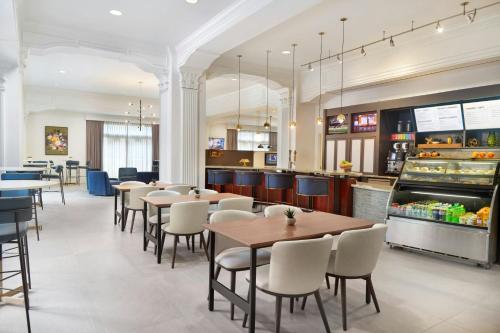 Courtyard by Marriott New Orleans French Quarter/Iberville في نيو أورلينز: مطعم به طاولات وكراسي ومنضدة