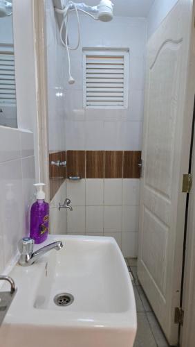 a bathroom with a white sink and a window at Tulivu homes in Ongata Rongai 
