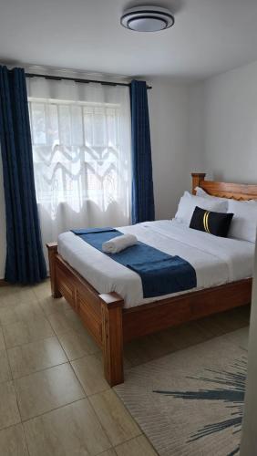 a bedroom with a large bed with a window at Tulivu homes in Ongata Rongai 