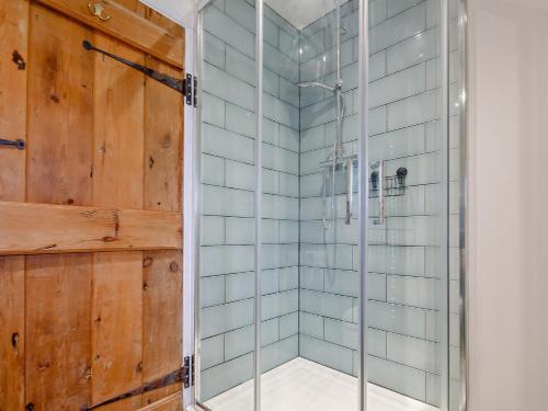 a shower with glass doors in a bathroom at 6 Bed in Harlech 91546 in Harlech