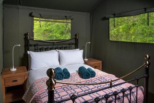 a bedroom with a bed with blue towels on it at Hebog Glamping Lodge in Talybont