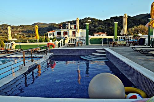 a swimming pool at a resort with a resort at Hotel Athena in Kokkari