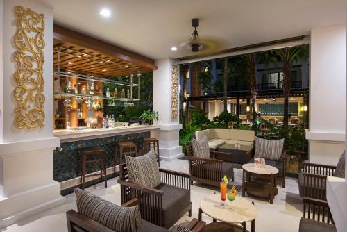a restaurant with a bar with chairs and tables at Centara Anda Dhevi Resort & Spa Krabi in Ao Nang Beach