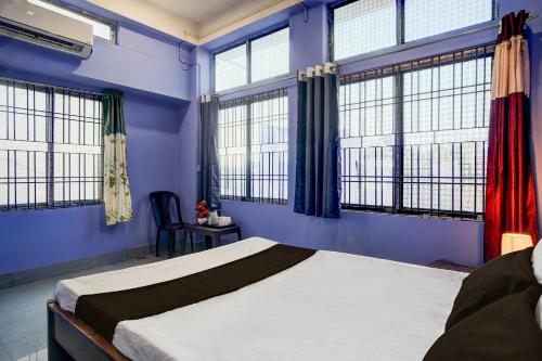 a bedroom with blue walls and windows and a bed at Hotel O Dream Lodge in Nowgong