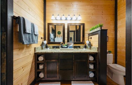 a bathroom with a sink and a mirror at Knotty and Nice Luxury Cabin in Broken Bow