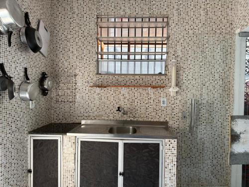 a small kitchen with a sink and a window at Quartos compartilhados COP30 - BRL in Belém