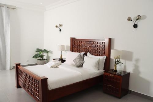 a bedroom with a large bed with white sheets and pillows at La Villa Grenade in Pointe-Noire