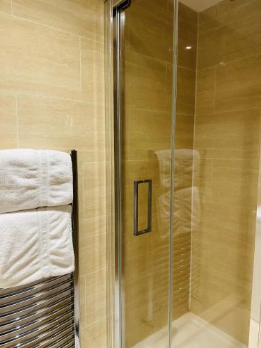 a glass shower with towels in a bathroom at Westferry Deluxe Apartment 3 in London