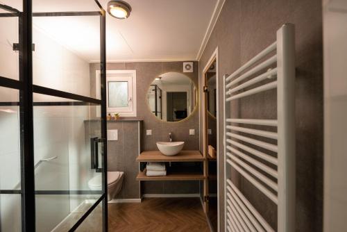 a bathroom with a sink and a mirror at Slow Living bij Mölke x Wellnesslodges in Zuna
