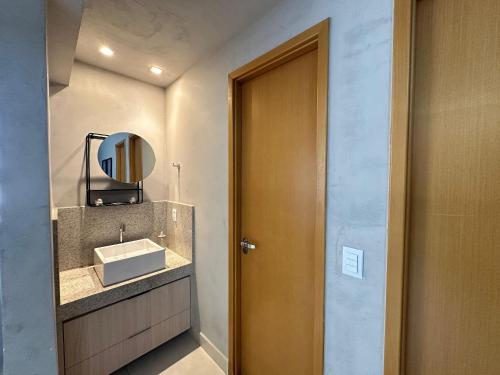a bathroom with a sink and a mirror at iFlat Lozandes Flamboyant Jardim Goiás in Goiânia