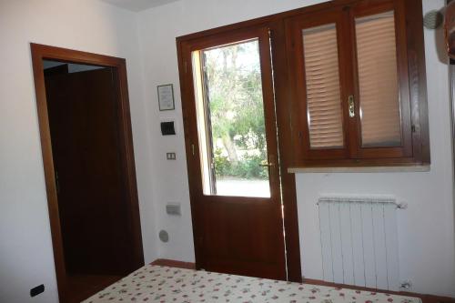 a room with a door and a window and a bed at PODERE OSLAVIA AZ.AGR.BIO GIANNINI in Alberese
