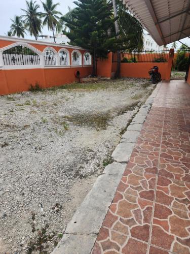 Ein Gehweg vor einem Haus, auf dem ein Motorrad geparkt ist. in der Unterkunft Hogar cerca de la playa in Punta Cana