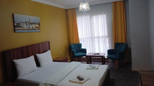 een hotelkamer met een bed en twee stoelen bij Ay suit in Esenyurt