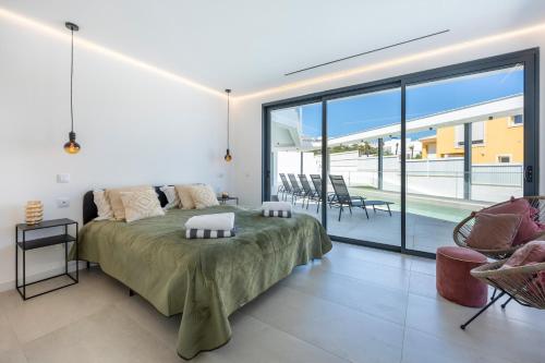 a bedroom with a large bed and a balcony at Villa Dominica in Páteo