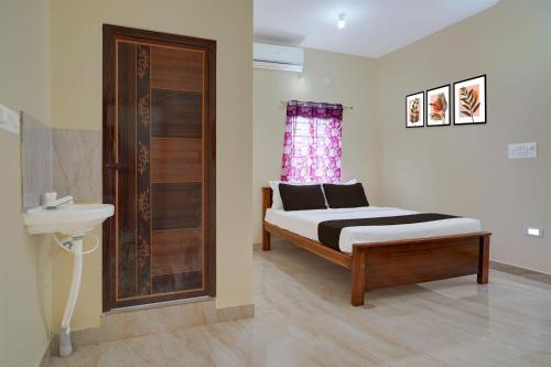 a bedroom with a bed and a sink and a window at Hotel O Kalpatharu Boarding and Lodging in Tyāmagondal
