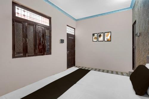 a room with a black and white floor and a window at Hotel O Shubh Inn in Jhānsi